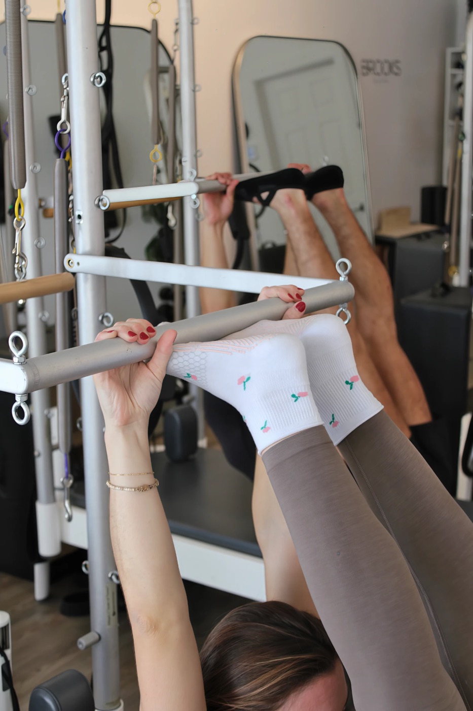 Feet and hands on the Tower bar in a Tower Pilates class